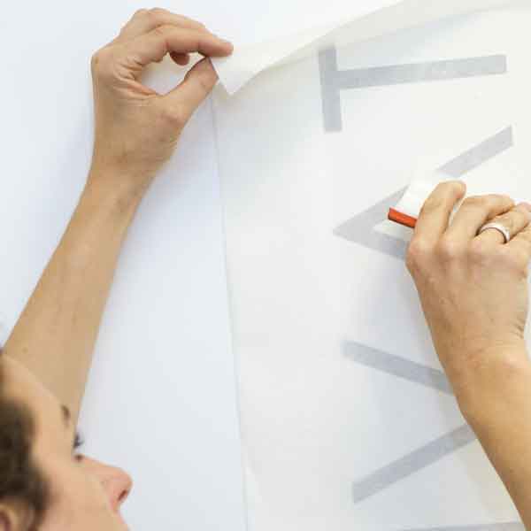 image of cut vinyl lettering being applied to a wall